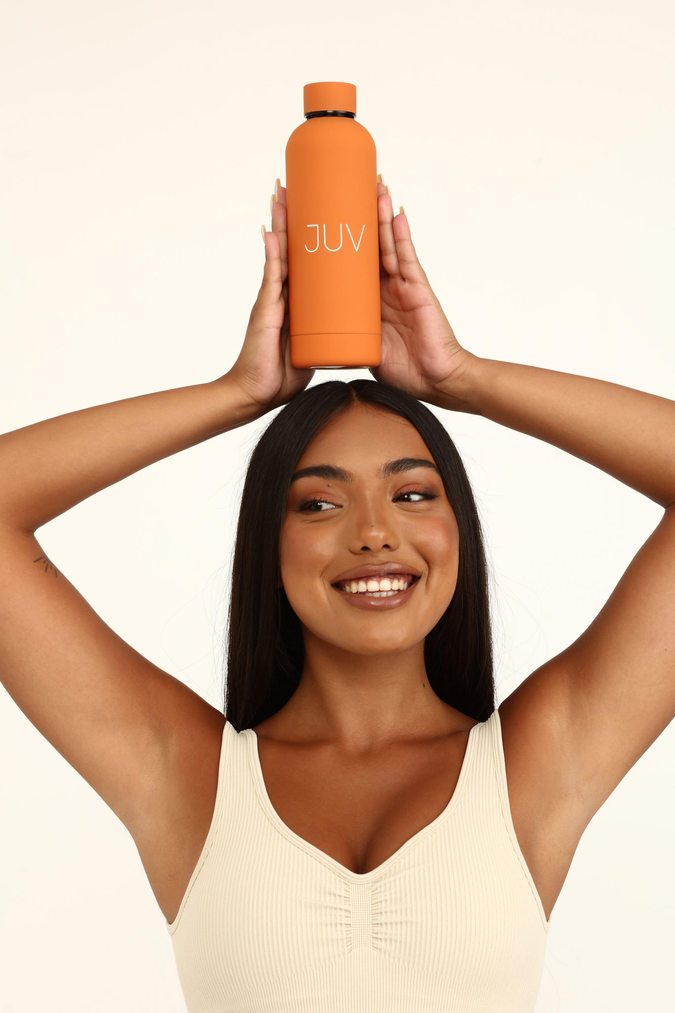 JUV mia thermal bottle in orange, front view, model holding it above her head.